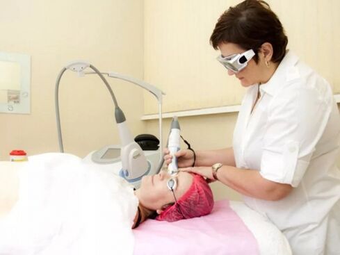 The cosmetologist performs a laser rejuvenation procedure